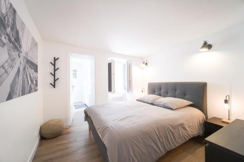 une chambre blanche avec un grand lit dedans dans l'établissement Appart' Terrasse plein centre, à La Ferté-Gaucher