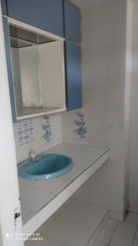y baño con lavabo azul y espejo. en Hermoso apto en en Rodadero 10A en Santa Marta