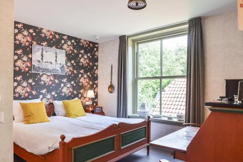 1 dormitorio con 1 cama y papel pintado con motivos florales en Hotel Frederiksoord en Frederiksoord