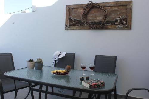 a table with a bowl of fruit and two glasses of wine at THE ROCK LUXURY HOMES in Mesaria