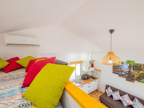 Schlafzimmer mit einem Bett mit roten und gelben Kissen in der Unterkunft Cubo's Greenlife Loft Total Privacy Pool in Alhaurín el Grande