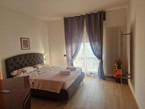 a bedroom with a bed and a large window at Nataly in SantʼAmbrogio di Valpolicella