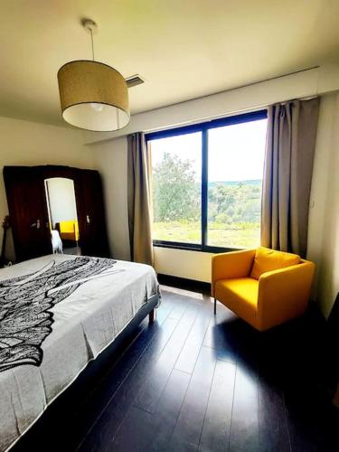 une chambre avec un lit, une chaise et une fenêtre dans l'établissement Maison vue sur le village, à Cotignac