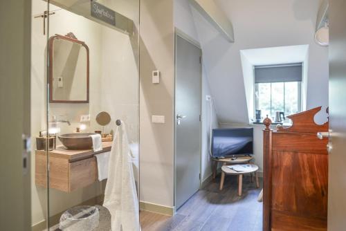 a bathroom with a sink and a mirror at Hotel Frederiksoord in Frederiksoord