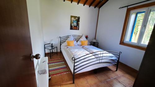 een bed in een kamer met een raam bij Casa Azul in Rabo de Peixe