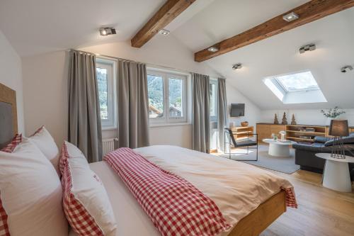 a bedroom with a bed and a living room at Landhaus Ohrwumslar in Oberstdorf