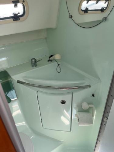 een badkamer met een witte wastafel en een spiegel bij Bateau Nirvana 7,6 m in Beaulieu-sur-Mer