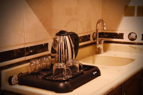 a coffee maker on a counter next to a sink at Al Andlus Palace Hotel 2 in Al Madinah