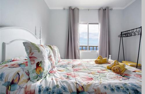 a bedroom with a bed with yellow shoes on it at Casa da Ribeira da Janela in Porto Moniz
