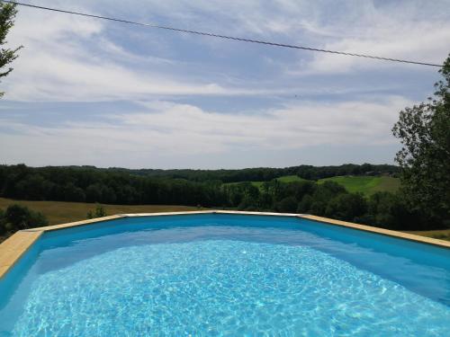 - une piscine bleue avec vue sur la campagne dans l'établissement Maison en pleine nature, à Peyrilles