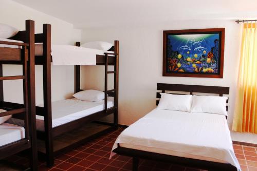 タガンガにあるHotel San Marcos Tagangaの二段ベッド2組が備わる客室で、壁には絵画が飾られています。
