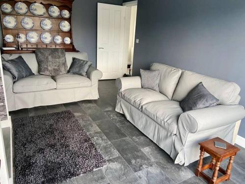 uma sala de estar com dois sofás brancos e uma mesa em Bryn Mair cottage overlooking Snowdon em Caernarfon