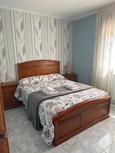 ein Schlafzimmer mit einem Bett mit einem Kopfteil aus Holz in der Unterkunft Casa ceferino in Barreiros