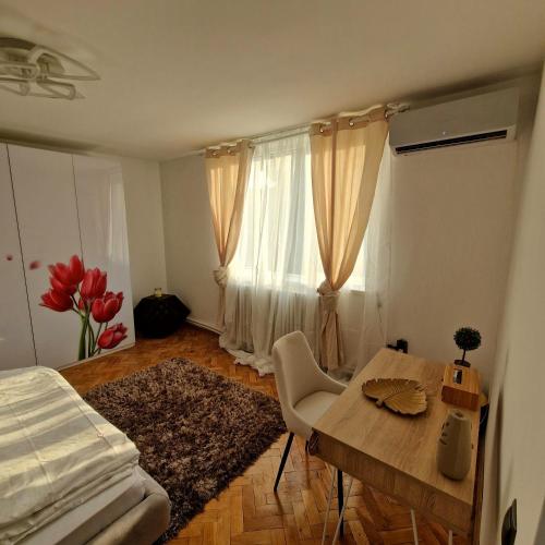 a bedroom with a table and a bed and a window at Vila Gruia in Cluj-Napoca