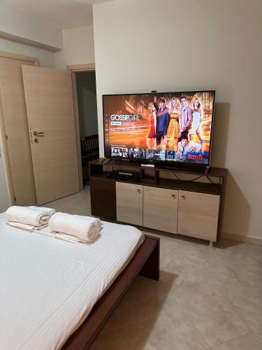 a bedroom with a flat screen tv and a bed at Luxury Villa Magic View 4U - katarina in Kineta