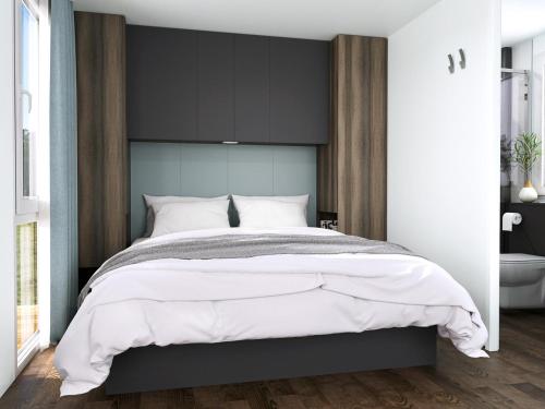 a bedroom with a large bed with a black headboard at Club del Sole Jesolo Family Resort in Lido di Jesolo