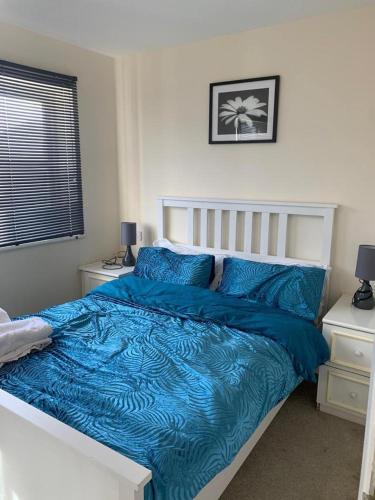 een slaapkamer met een bed met een blauw dekbed bij Charming 2-Bed House in London in Londen