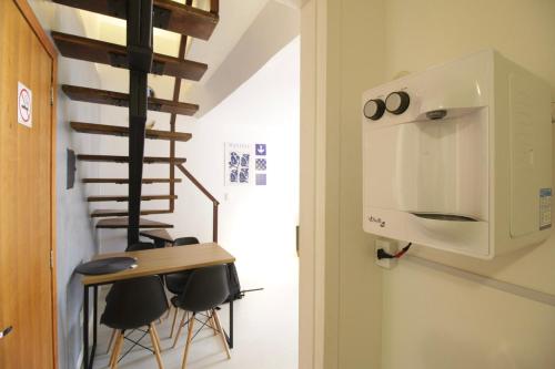 a room with a table and chairs and a spiral staircase at FLAT W3 Norte in Brasília