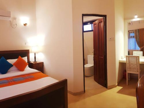 a bedroom with a bed and a door to a bathroom at MyHavelock Town Studio Apt, with Own Pvt Gate Parking in Main City in Nawala