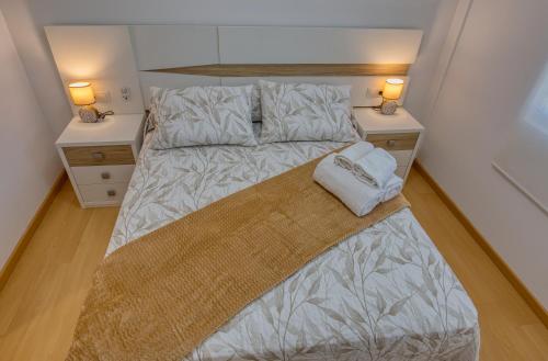 a bedroom with a large bed with two night stands at O Aserradero in Finisterre