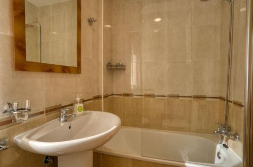 ein Badezimmer mit einem Waschbecken und einer Badewanne in der Unterkunft O Aserradero in Kap Finisterre