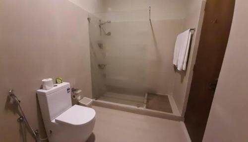 a white bathroom with a shower and a toilet at MYH - Lake Front Pvt Villa with Staff and Includes FREE Breakfast of your choice in Bandaragama