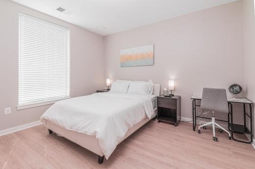 a white bedroom with a bed and a desk at Luxury Living City Views DC in Arlington