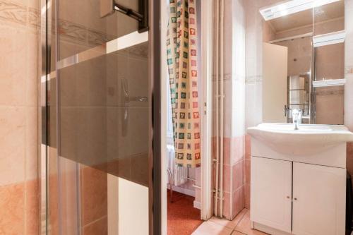 a bathroom with a sink and a shower at Logis Hôtel La crémaillère in Hagetmau
