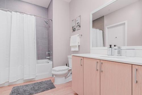 a bathroom with a sink and a toilet and a tub at Luxury Living City Views DC in Arlington