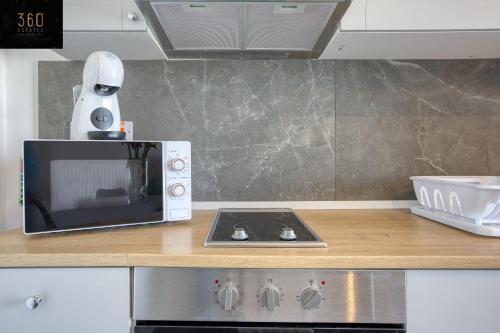 a microwave oven sitting on top of a kitchen counter at Gzira's Seashore Stayaway close to Manuel Island in Il-Gżira