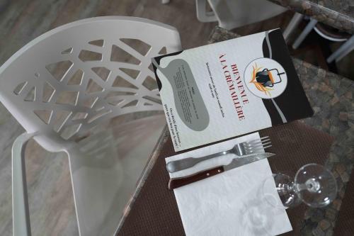 a table with a box and a fork and knife at Logis Hôtel La crémaillère in Hagetmau