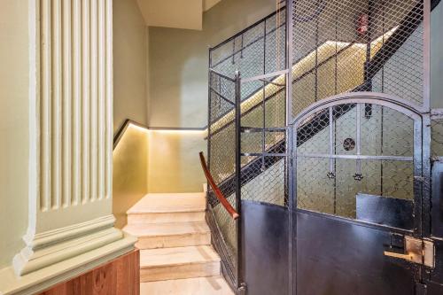 un escalier avec une porte métallique dans un bâtiment dans l'établissement Sweet Inn - Aragon Park Miro, à Barcelone
