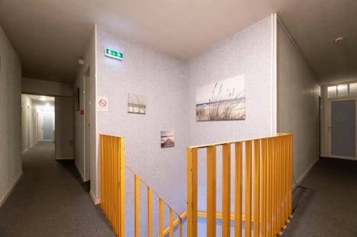 a hallway with a yellow staircase in a building at Logis Hôtel La crémaillère in Hagetmau