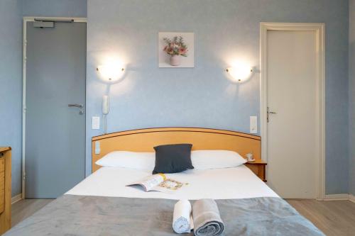 a bedroom with a bed with two towels on it at Logis Hôtel La crémaillère in Hagetmau