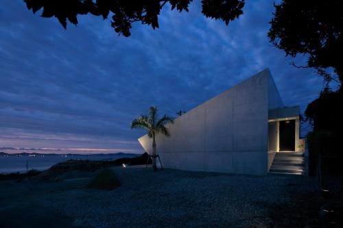 a building with a palm tree in front of it at VILLA WHITE in Sesoko