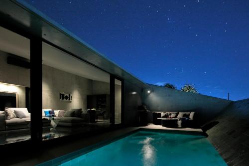 a house with a swimming pool at night at VILLA WHITE in Sesoko