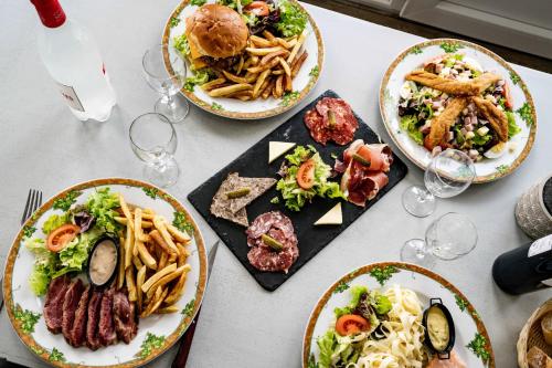 a table with plates of food and glasses of wine at Logis Hôtel La crémaillère in Hagetmau