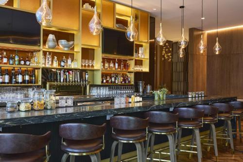 a bar with brown stools in a restaurant at The Westin Raleigh-Durham Airport in Raleigh