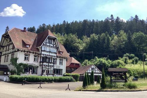 ein großes weißes und schwarzes Gebäude auf einer Straße in der Unterkunft Hotel B&B Steinasäge in Bonndorf im Schwarzwald