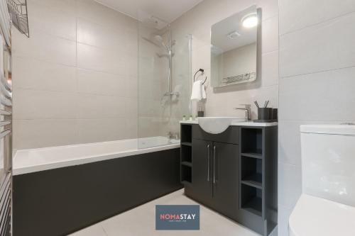 a bathroom with a sink and a bath tub and a sink at NOMASTAY, Corporate, Families, Relocation, 3 bed, 2 bath, Parking, next to the hospital, university, city center in Sheffield