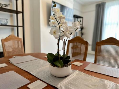 a vase with white flowers on a wooden table at 101A Moss Lane in Walton on the Hill