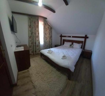 a small bedroom with a bed and a window at Casa pintioi in Ieud