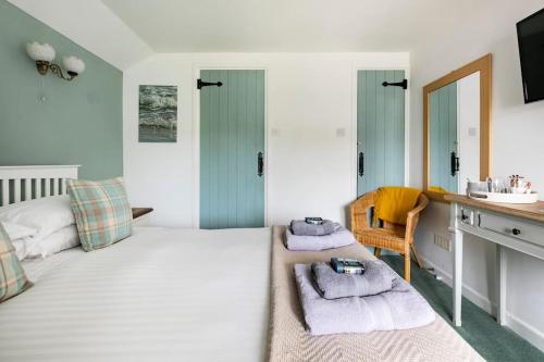 1 dormitorio con cama, escritorio y lavamanos en Kota Restaurant & Rooms en Porthleven