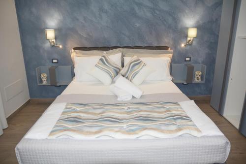 ein Schlafzimmer mit einem großen weißen Bett mit Kissen in der Unterkunft Triskelion in Nunziata