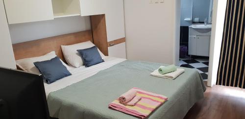 a bedroom with a bed with towels on it at Kuća Pećine in Metajna