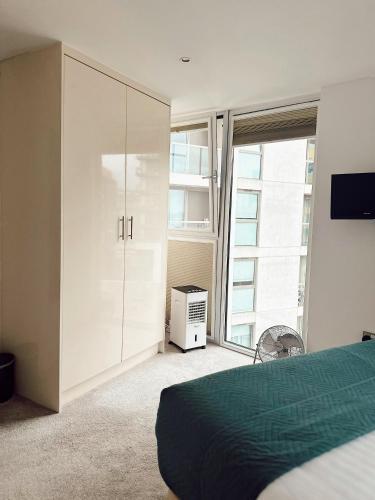 a bedroom with a bed and a large window at Canary Wharf - Luxury Apartments in London