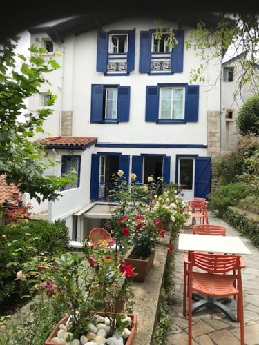 a blue and white house with flowers in front of it at Hôtel Ohartzia in Saint-Jean-de-Luz