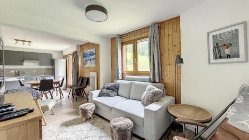 un salon avec un canapé et une cuisine dans l'établissement Grand Cerf 57 58, à Saint-Jean-dʼAulps