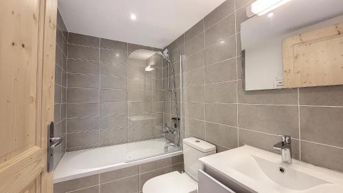 une salle de bain avec toilettes, baignoire et lavabo dans l'établissement Grand Cerf 57 58, à Saint-Jean-dʼAulps