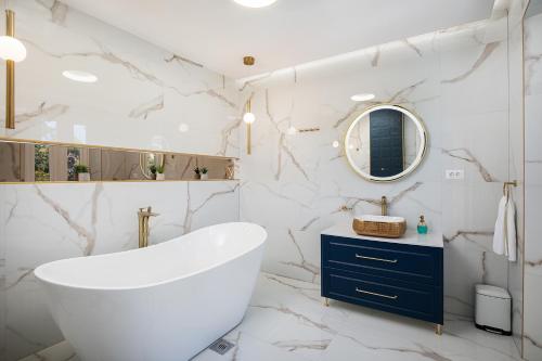a bathroom with a large white tub and marble walls at Via Flavia Luxury Accommodation with FREE private parking in Pula